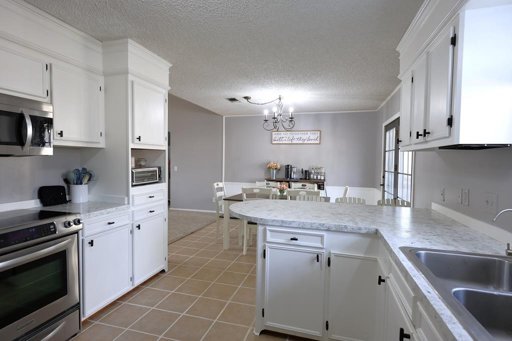 235 Spring Branch Street Lufkin, TX 75904 - Photo 3 of 30 a kitchen with granite countertop a sink stove and cabinets