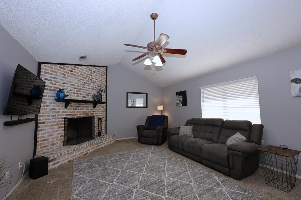 235 Spring Branch Street Lufkin, TX 75904 - Photo 6 of 30 a living room with furniture a fireplace and a flat screen tv