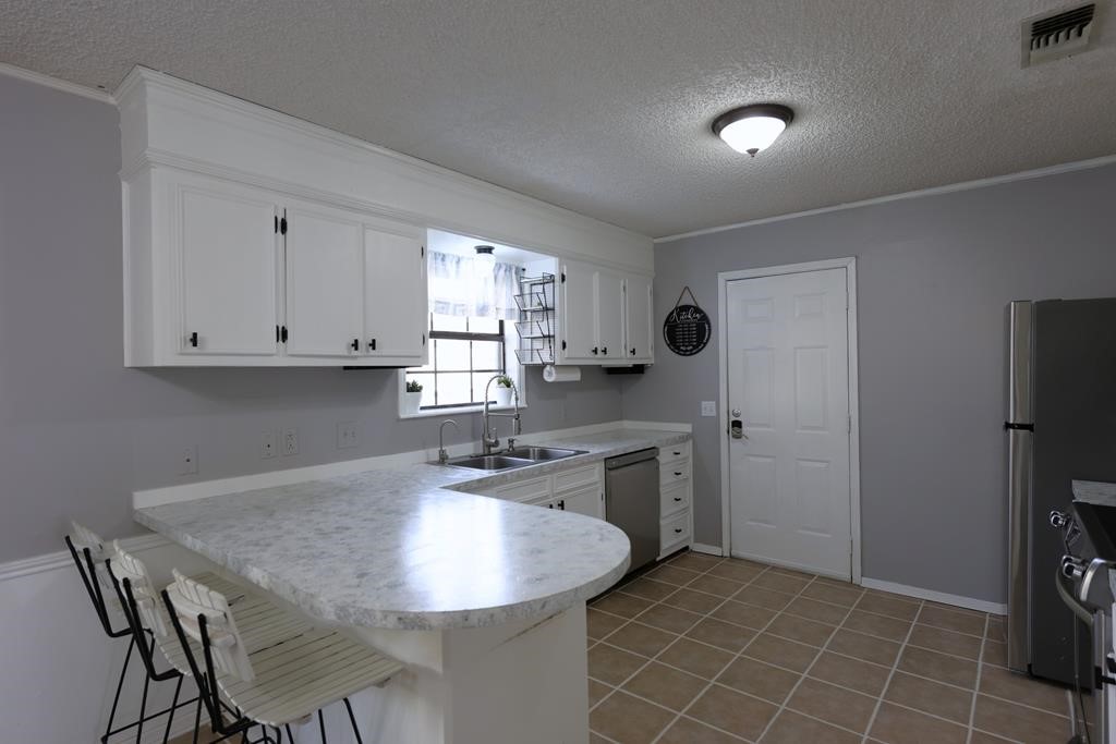 235 Spring Branch Street Lufkin, TX 75904 - Photo 9 of 30 a kitchen with stainless steel appliances granite countertop a sink and a refrigerator