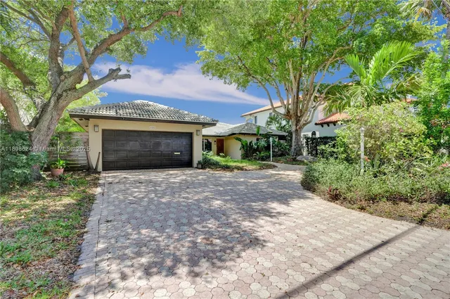 front view of a house with a garden and an trees