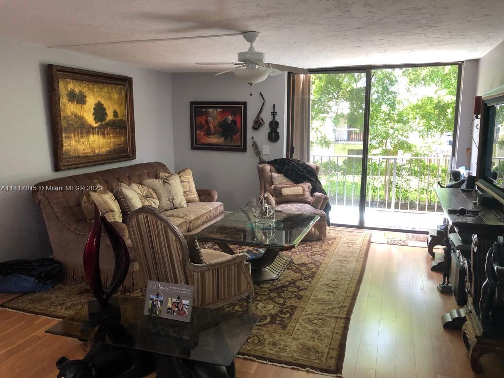 450 Commodore Drive, Unit 211 Plantation, FL 33325 - Photo 1 of 12 a living room with furniture and a flat screen tv