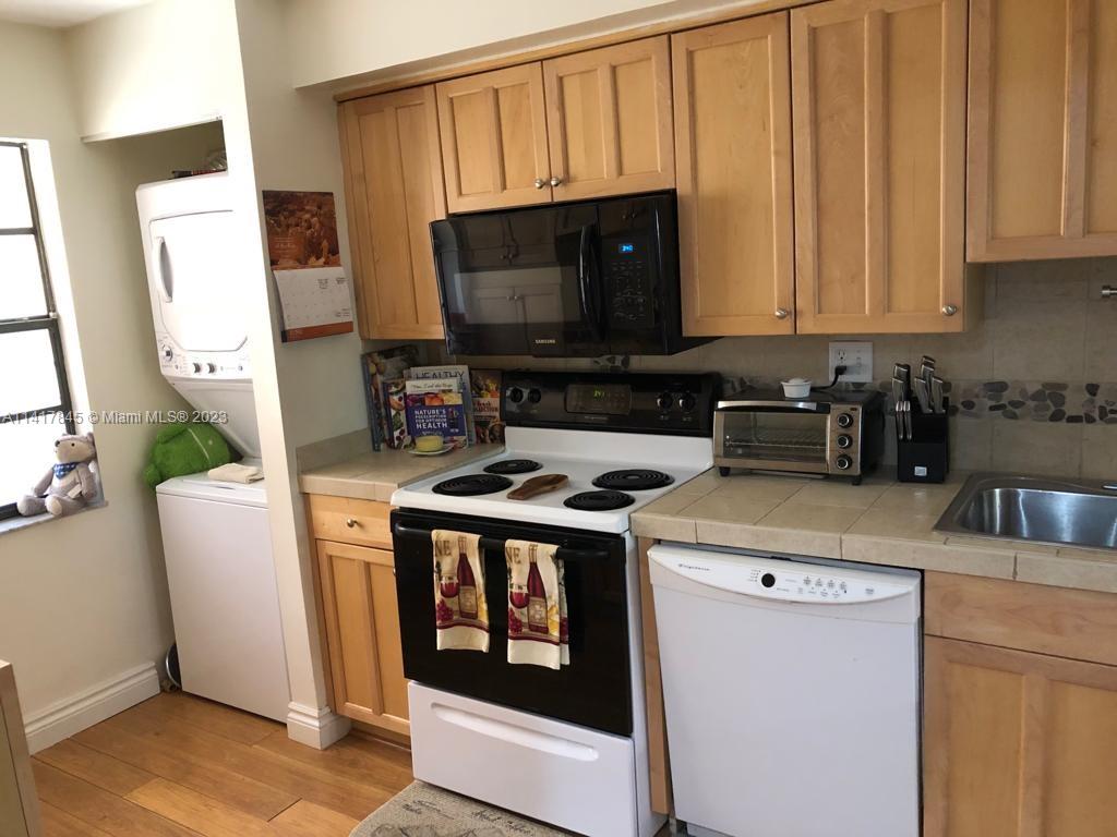 450 Commodore Drive, Unit 211 Plantation, FL 33325 - Photo 5 of 12 a kitchen with a stove and a microwave