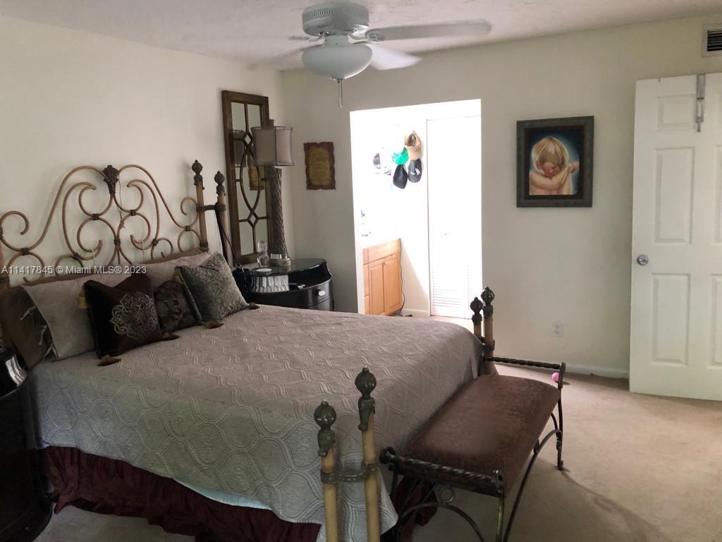 450 Commodore Drive, Unit 211 Plantation, FL 33325 - Photo 6 of 12 a bedroom with a bed and wooden floor
