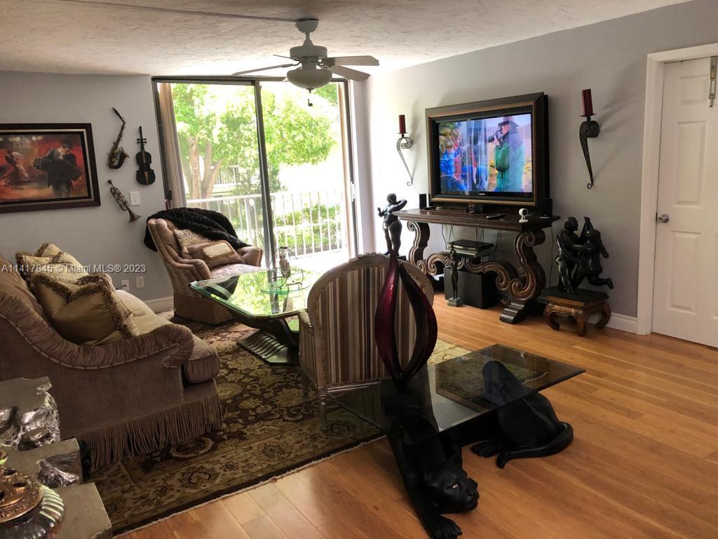 450 Commodore Drive, Unit 211 Plantation, FL 33325 - Photo 9 of 12 a room with furniture and a flat screen tv