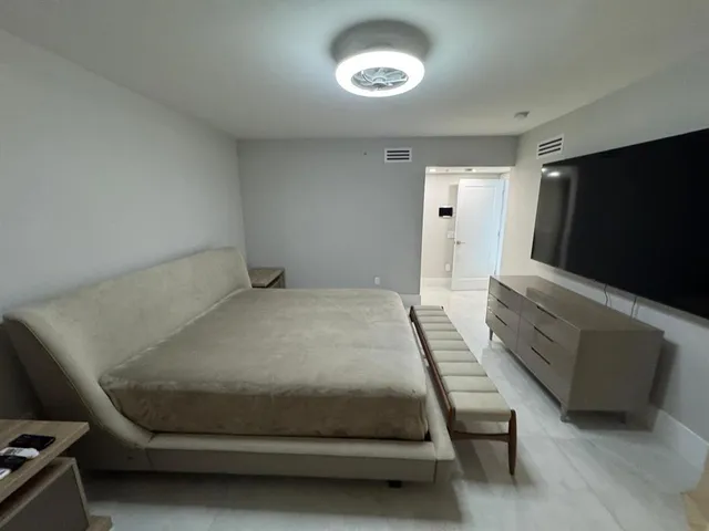 a living room with furniture a chandelier and a flat screen tv