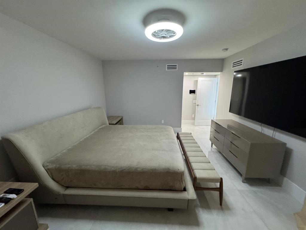 2051 Southeast 3rd Street, Unit 406 Deerfield Beach, FL 33441 - Photo 16 of 61 a bedroom with a bed and a flat screen tv