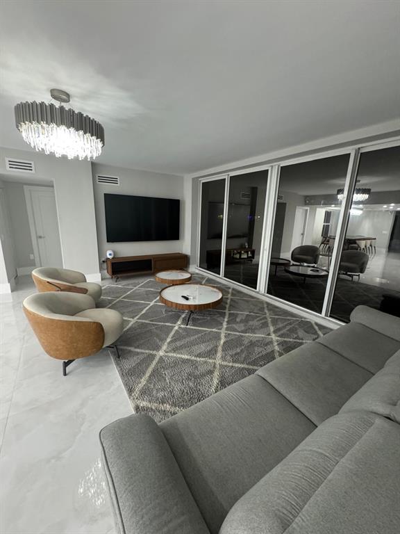 2051 Southeast 3rd Street, Unit 406 Deerfield Beach, FL 33441 - Photo 23 of 61 a living room with furniture and a flat screen tv