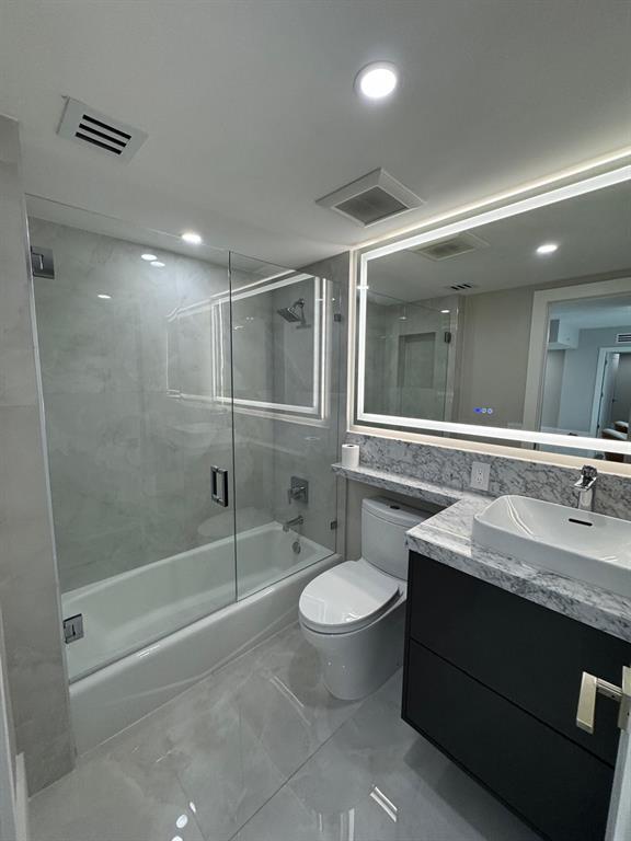 2051 Southeast 3rd Street, Unit 406 Deerfield Beach, FL 33441 - Photo 30 of 61 a bathroom with a granite countertop sink toilet and shower