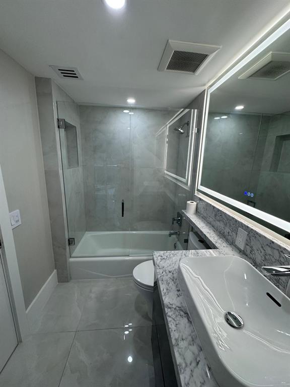 2051 Southeast 3rd Street, Unit 406 Deerfield Beach, FL 33441 - Photo 32 of 61 a bathroom with a granite countertop sink a toilet and shower