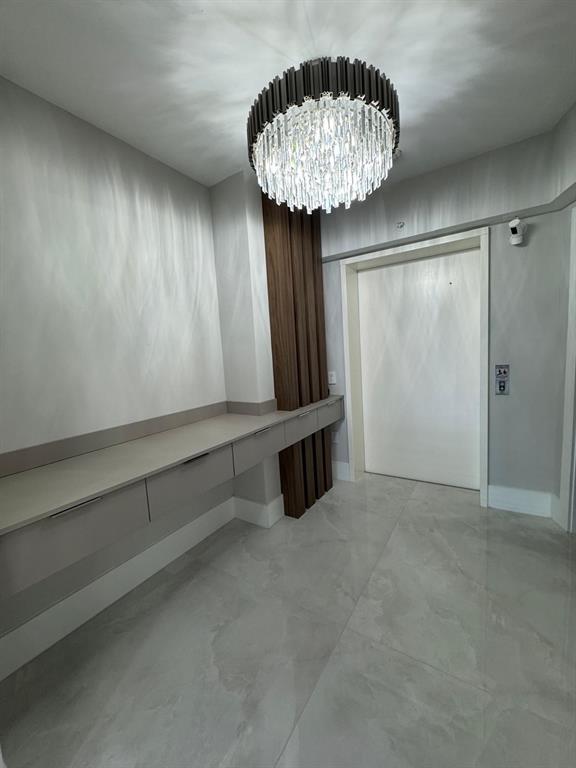 2051 Southeast 3rd Street, Unit 406 Deerfield Beach, FL 33441 - Photo 38 of 61 an empty room with a chandelier