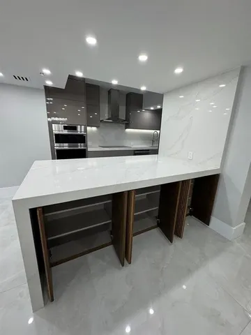 a large parking space with stainless steel appliances a refrigerator and a sink