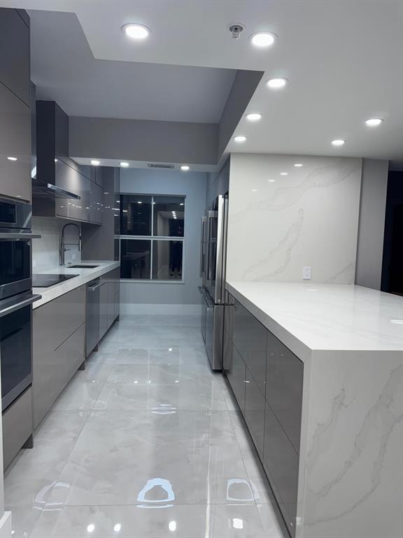 2051 Southeast 3rd Street, Unit 406 Deerfield Beach, FL 33441 - Photo 60 of 61 a large parking space with stainless steel appliances a refrigerator and a sink