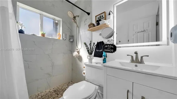 a bathroom with a sink a toilet and shower