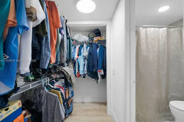 a view of walk in closet with clothes