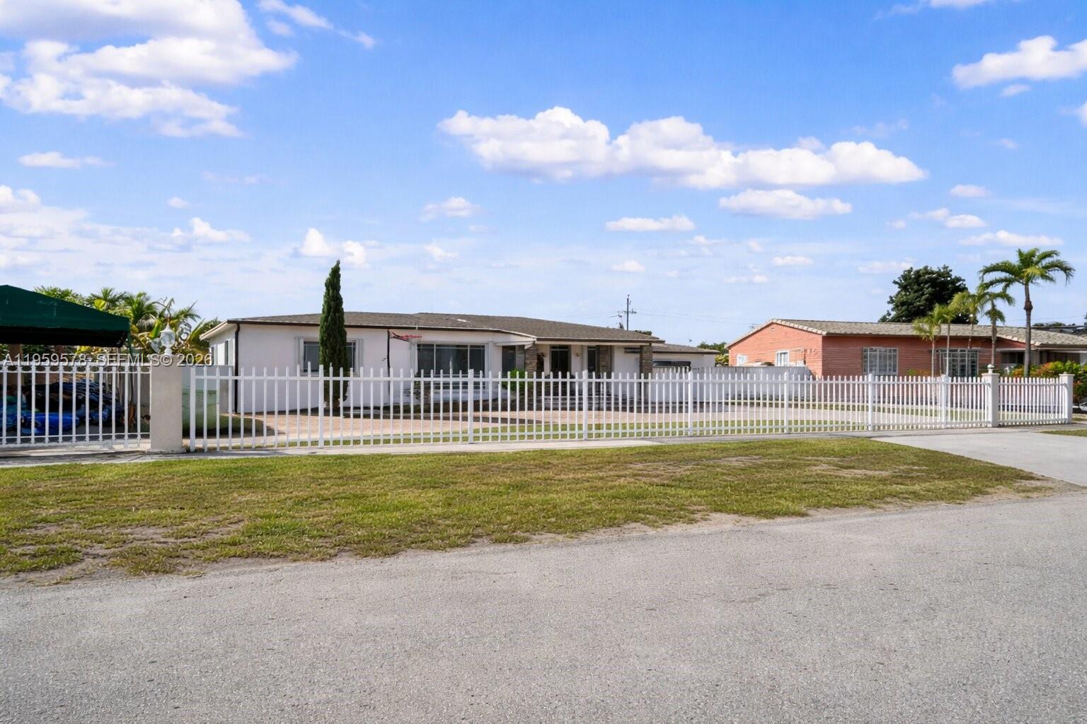 360 West 55th Street Hialeah, FL 33012 - Photo 2 of 20 a view of a house with a swimming pool and a yard