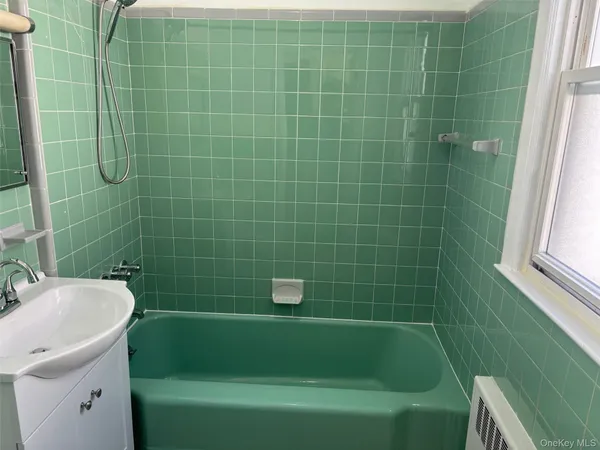 a bathroom with a sink a toilet a bathtub and window