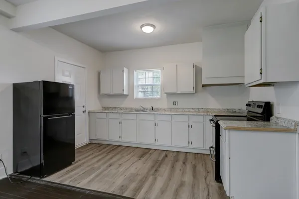 a kitchen with a refrigerator sink and cabinets