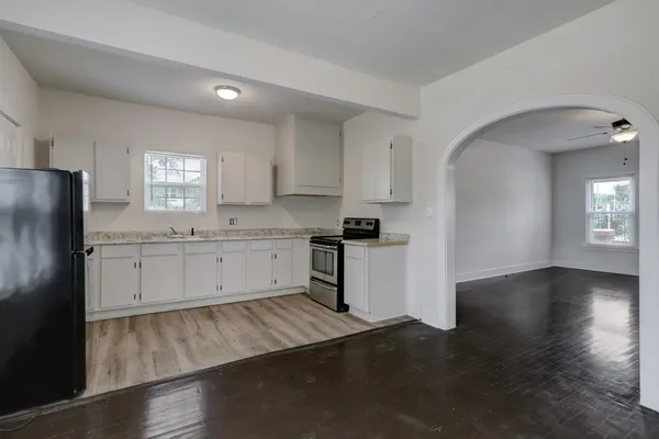 a kitchen with a refrigerator stove and white cabinets
