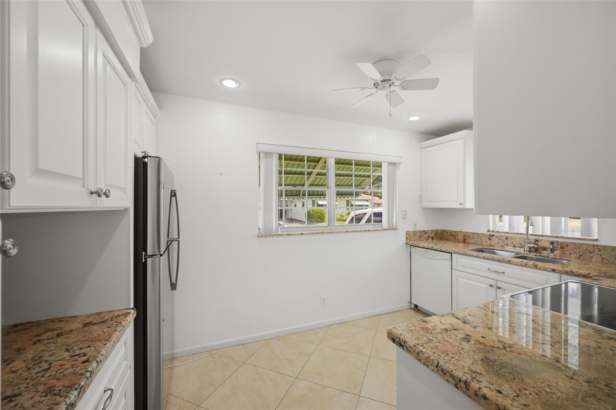 602 Hummingbird Lane, Unit 602 Delray Beach, FL 33445 - Photo 16 of 31 a kitchen with granite countertop a stove a sink and a refrigerator