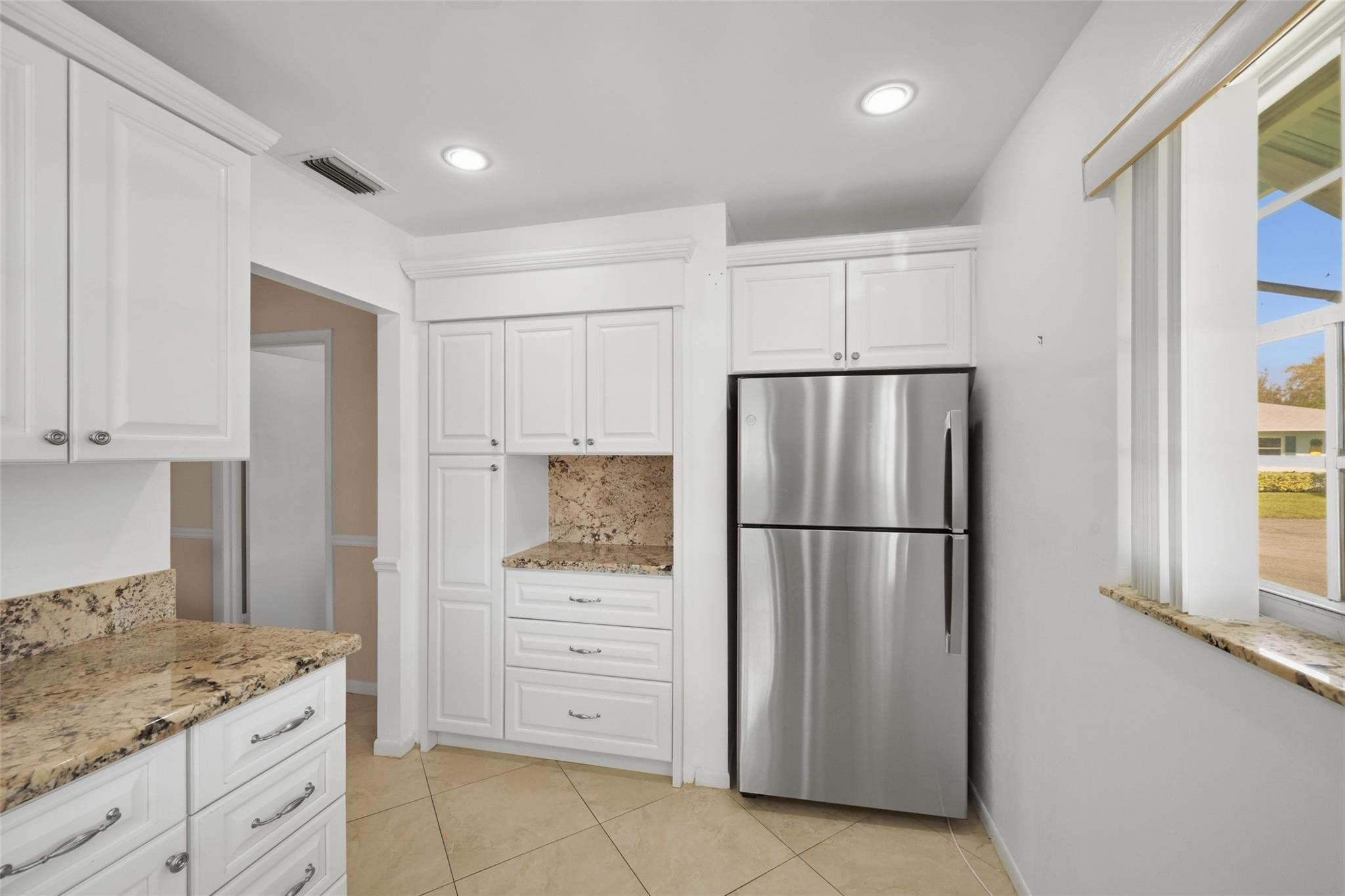 602 Hummingbird Lane, Unit 602 Delray Beach, FL 33445 - Photo 19 of 31 a kitchen with cabinets stainless steel appliances and a window