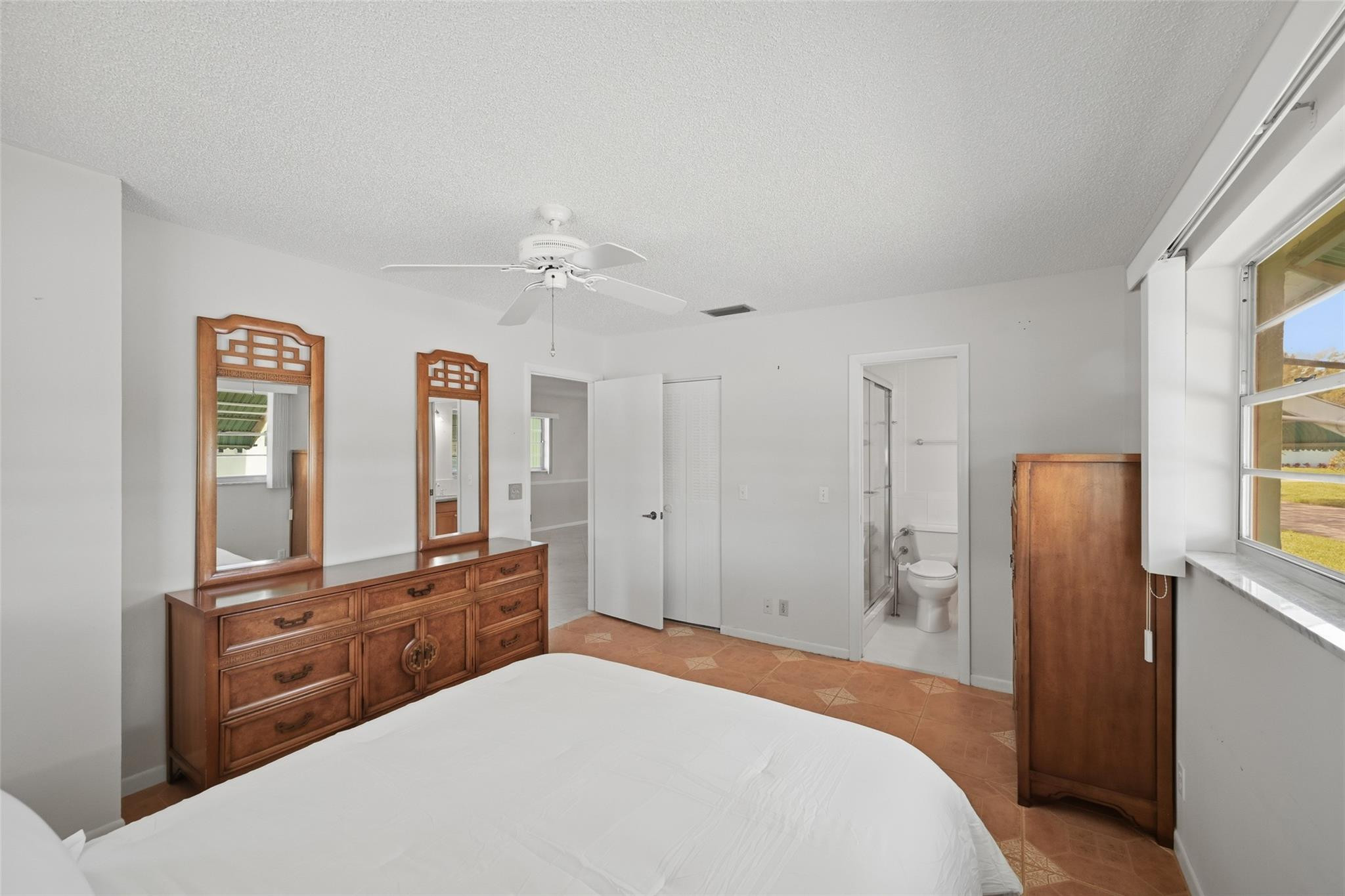 602 Hummingbird Lane, Unit 602 Delray Beach, FL 33445 - Photo 22 of 31 a spacious bedroom with a bed and a large mirror