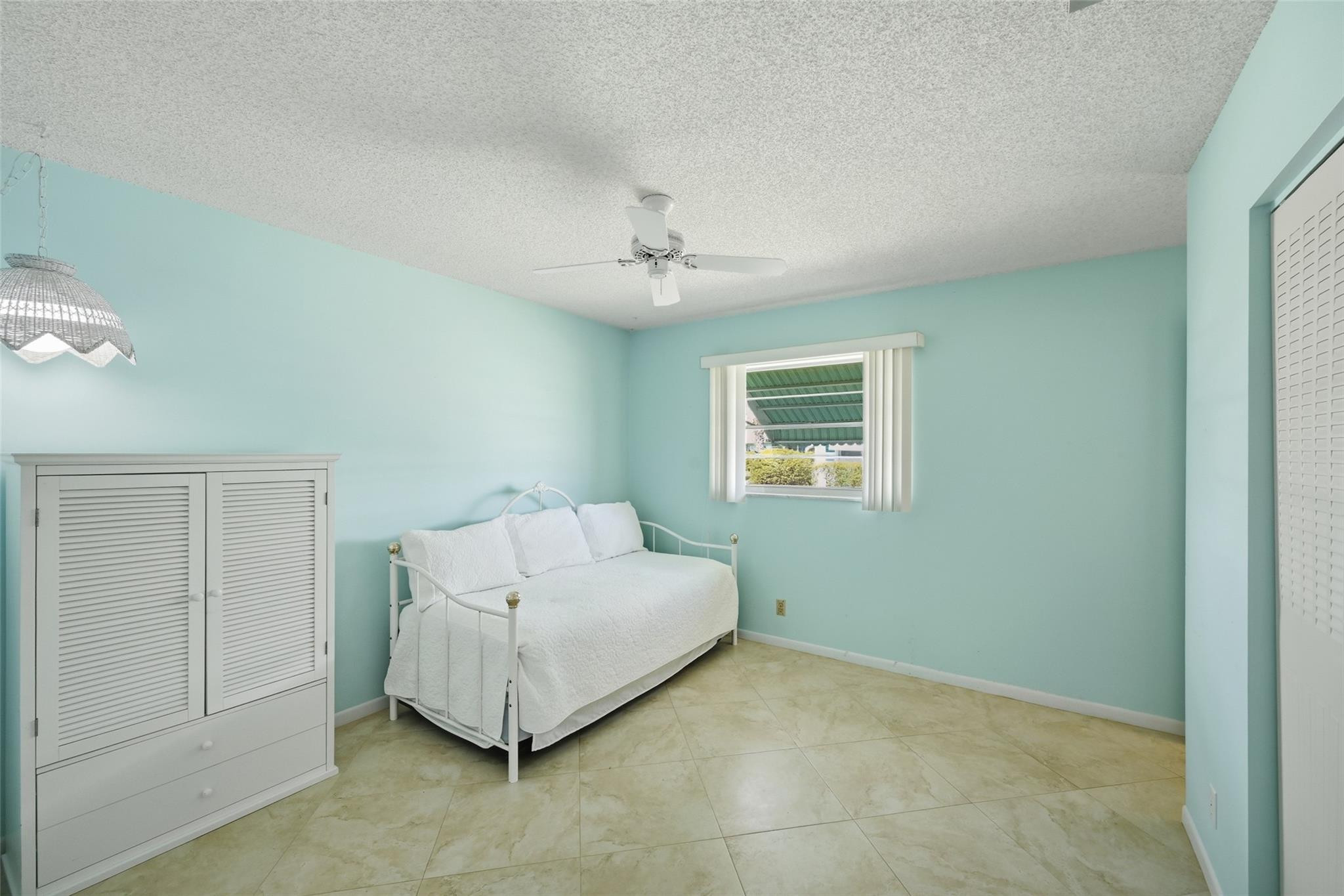 602 Hummingbird Lane, Unit 602 Delray Beach, FL 33445 - Photo 25 of 31 a living room with a couch and a ceiling fan