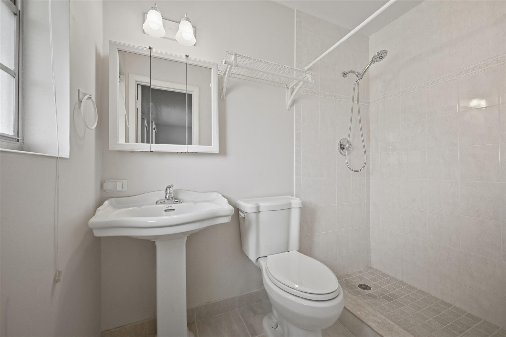 602 Hummingbird Lane, Unit 602 Delray Beach, FL 33445 - Photo 27 of 31 a bathroom with a toilet a sink and mirror