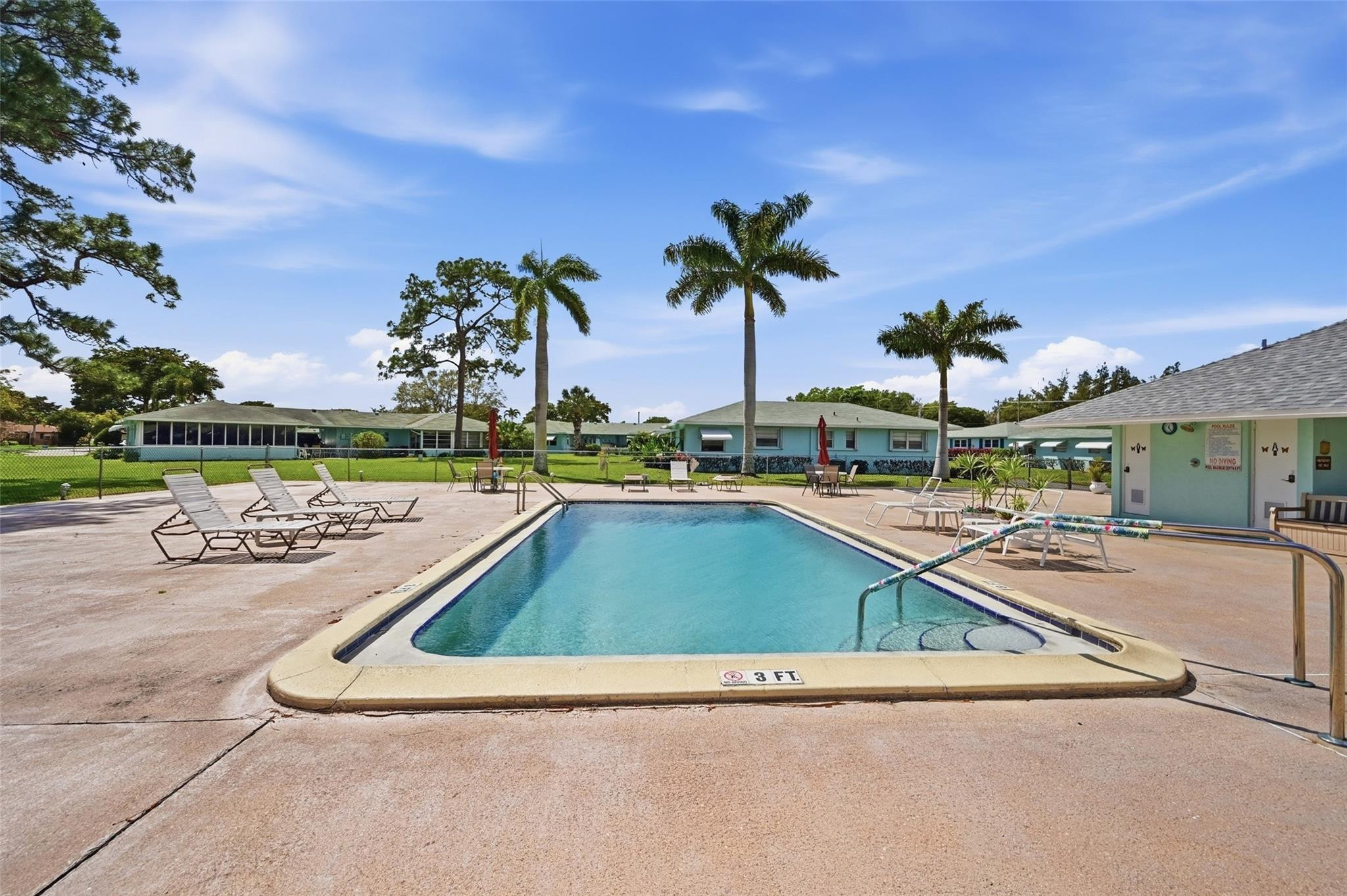 602 Hummingbird Lane, Unit 602 Delray Beach, FL 33445 - Photo 30 of 31 a view of a swimming pool and lounge chairs