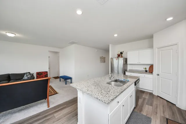 a kitchen with granite countertop a sink a stove and refrigerator