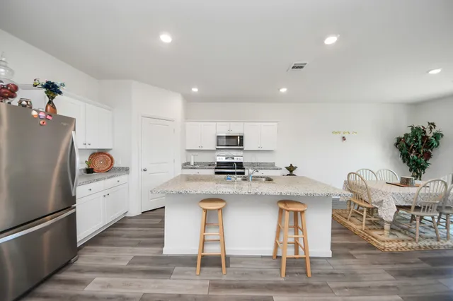 a kitchen with stainless steel appliances granite countertop a refrigerator stove microwave and sink