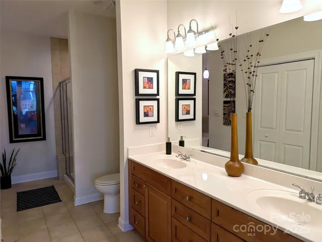 a bathroom with a double vanity sink mirror and toilet