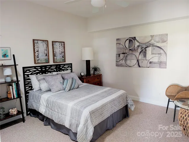 a bedroom with a bed and painting on the wall