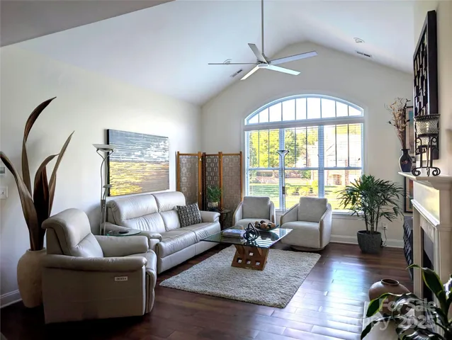 a living room with furniture fireplace and a large window