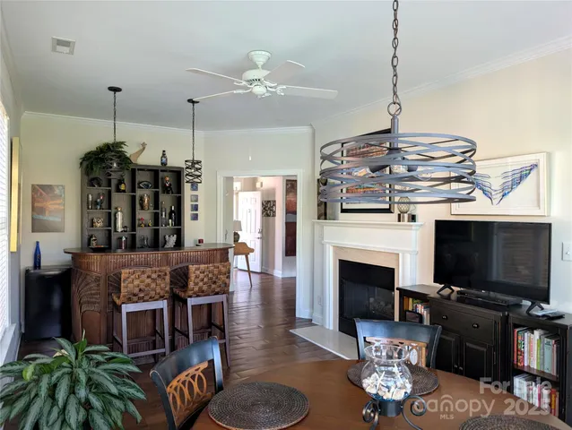 a living room with furniture a flat screen tv and kitchen view
