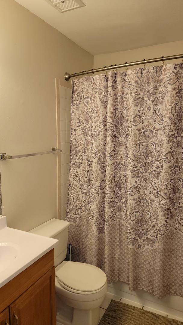 1810 Hemlock Place, Unit 209 Schaumburg, IL 60173 - Photo 11 of 13 a white toilet sitting next to a shower curtain