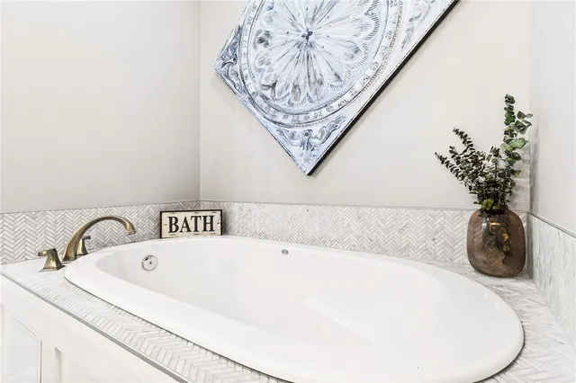 a spacious bathroom with a tub sink and mirror