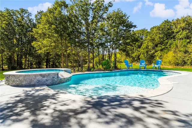 a swimming pool with outdoor seating and yard