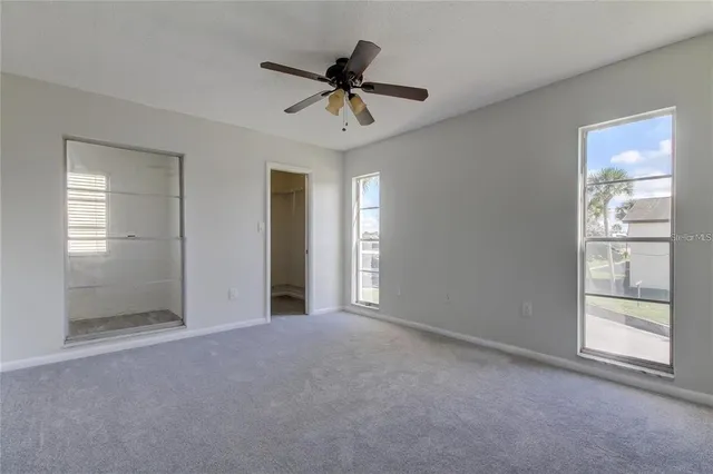 a bathroom with a granite countertop toilet a sink a mirror and bathtub