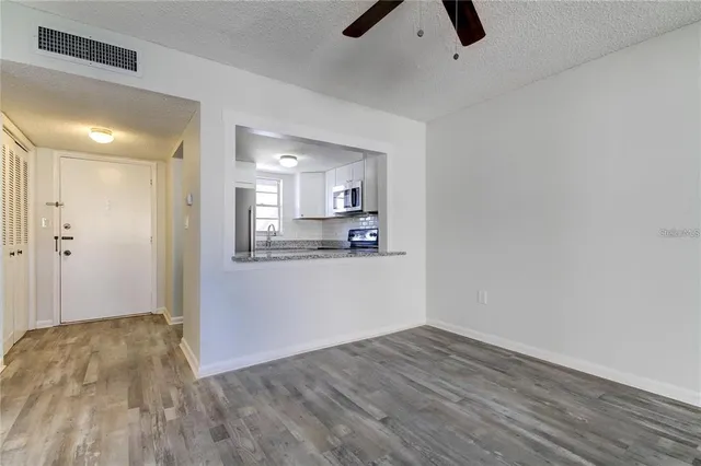 a view of a big room with wooden floor and windows