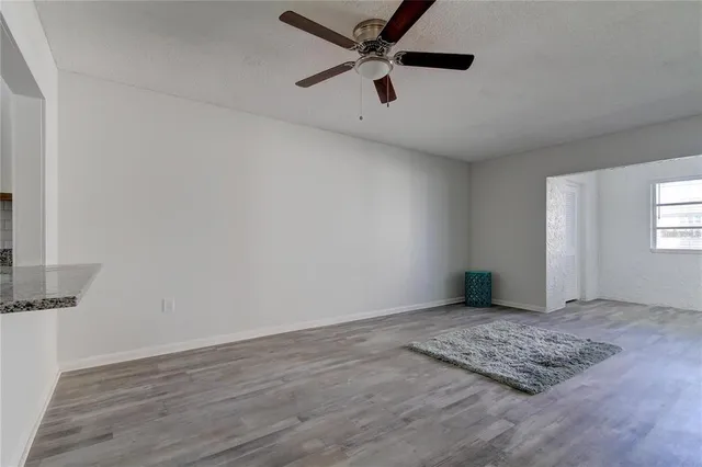 a view of an empty room with wooden floor and closet