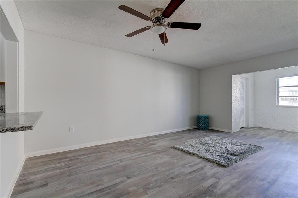 4901 Onyx Lane, Unit 204 New Port Richey, FL 34652 - Photo 5 of 46 an empty room with wooden floor fan and windows