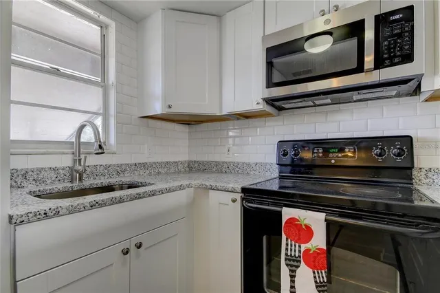 a kitchen with stainless steel appliances a stove a microwave and sink