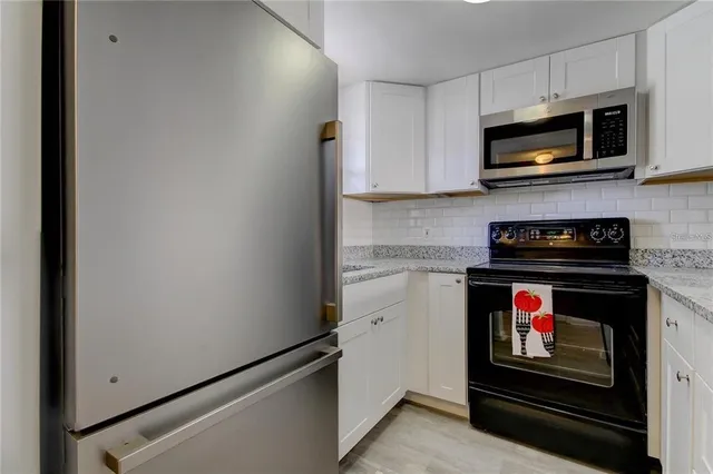 a kitchen with stainless steel appliances granite countertop a stove and a microwave