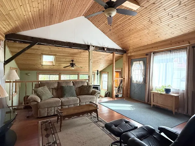 a living room with furniture a ceiling fan and a window