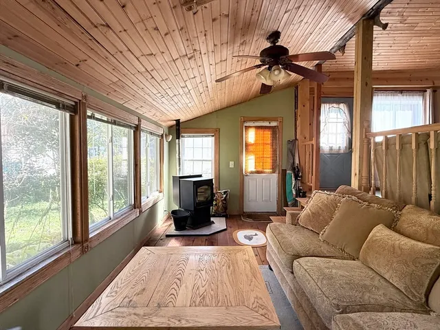 a living room with furniture a wooden floor and next to a window