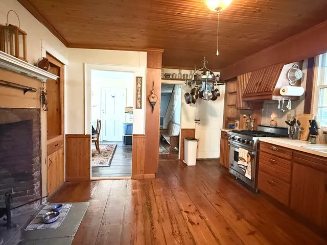 a view of a living room and kitchen with furniture and wooden floor
