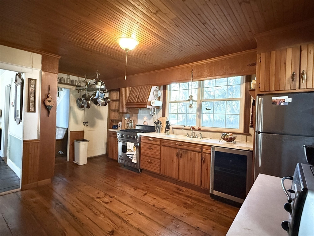 334 Elm Street West Springfield, MA 01089 - Photo 10 of 42 a kitchen with stainless steel appliances kitchen island granite countertop a refrigerator a sink dishwasher a stove and white countertops with wooden floor