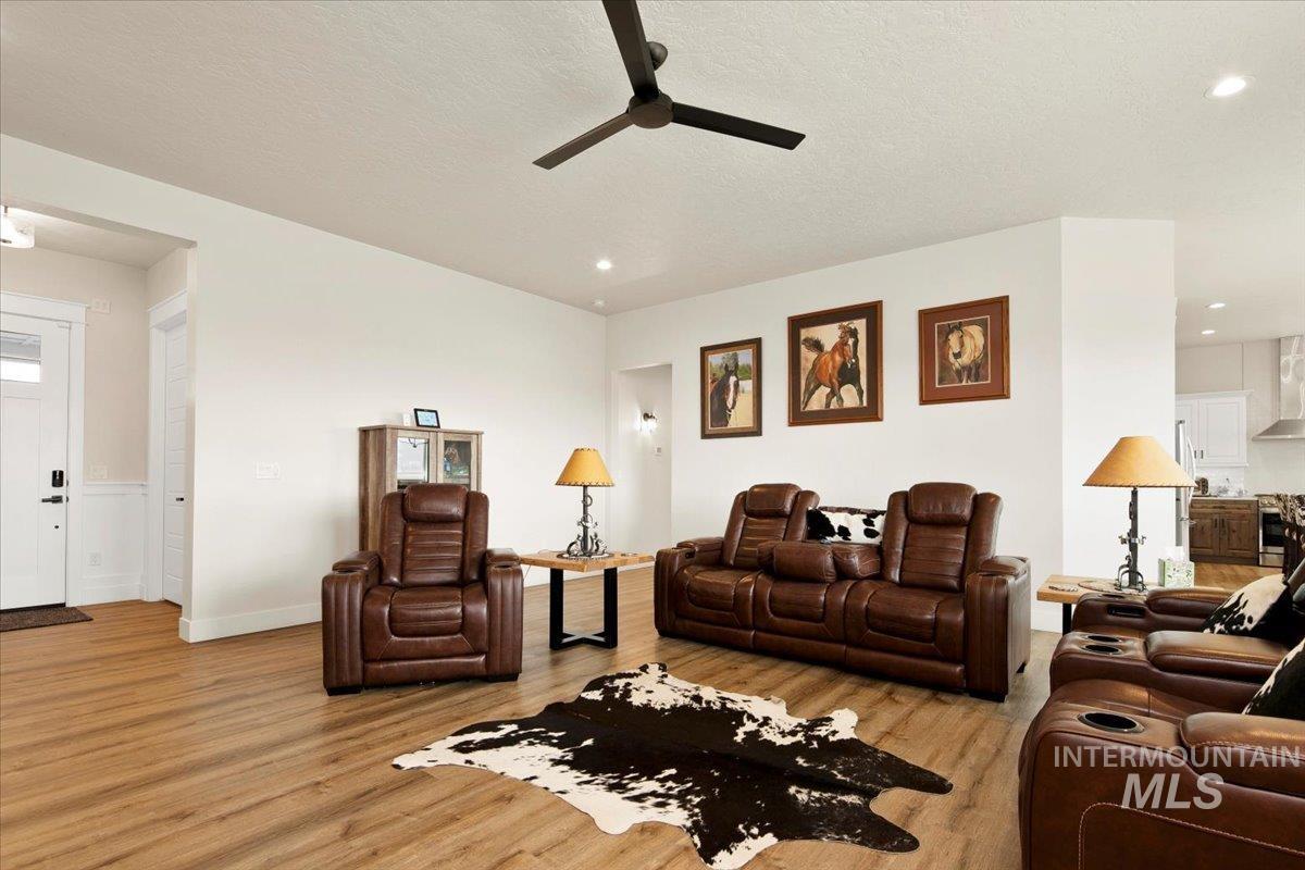6721 El Paso Road Caldwell, ID 83607 - Photo 13 of 50 Living area featuring light wood finished floors, ceiling fan, and a textured ceiling