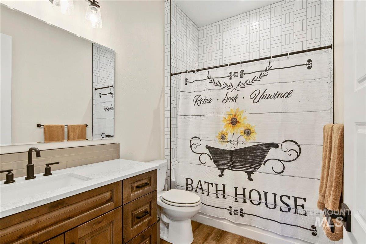 6721 El Paso Road Caldwell, ID 83607 - Photo 31 of 50 Full bath with vanity, shower / bath combination with curtain, and wood finished floors