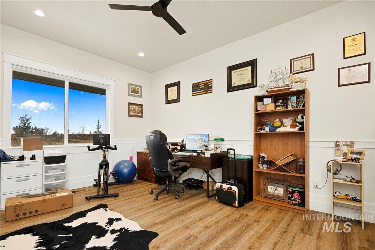 6721 El Paso Road Caldwell, ID 83607 - Photo 6 of 50 Home office with light wood-style flooring, a wainscoted wall, a ceiling fan, and recessed lighting